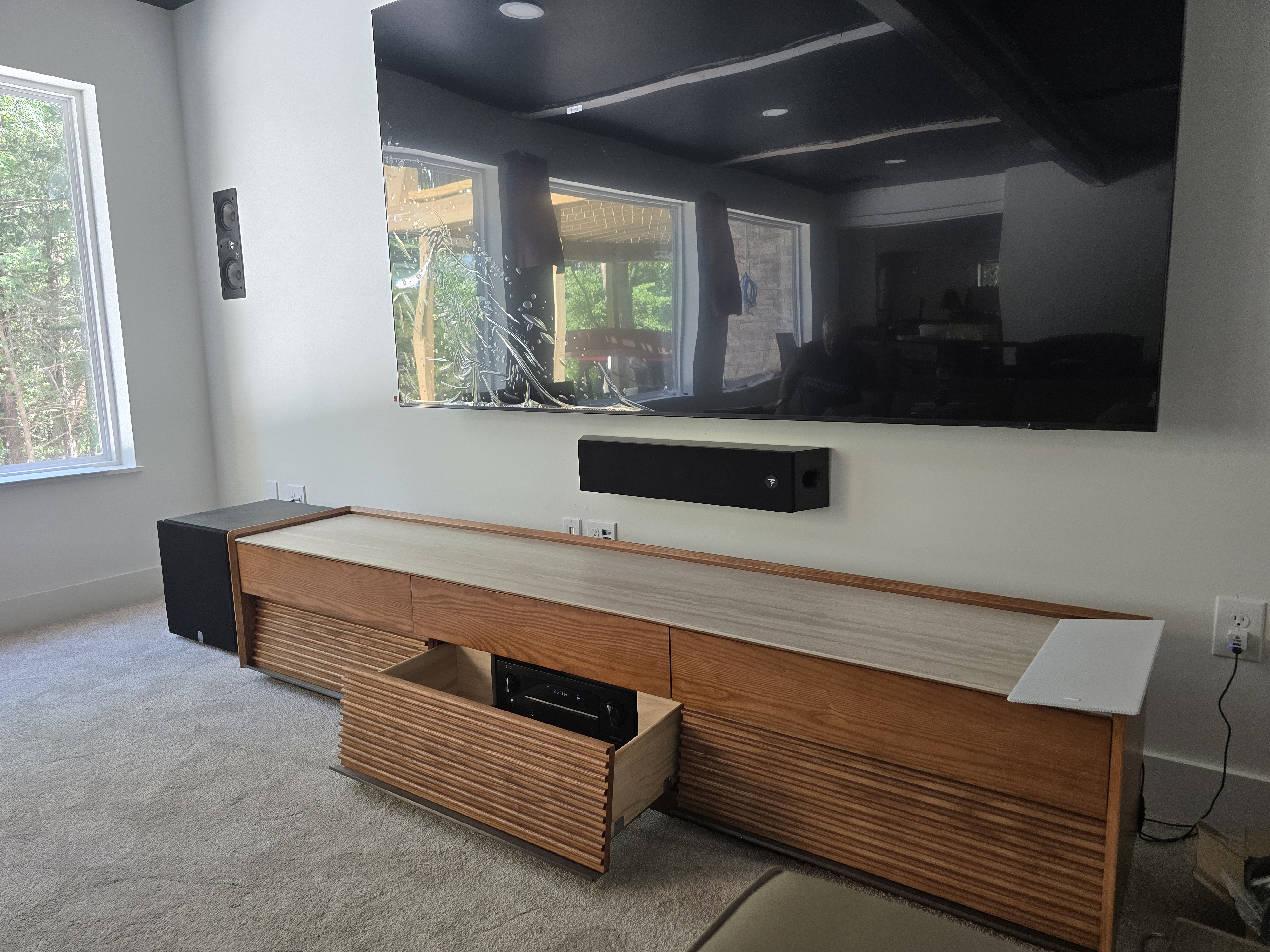 Hudkins Lake House — 80-inch QLED wall mount with Focal soundbar and custom slat-front credenza overlooking the lake view
