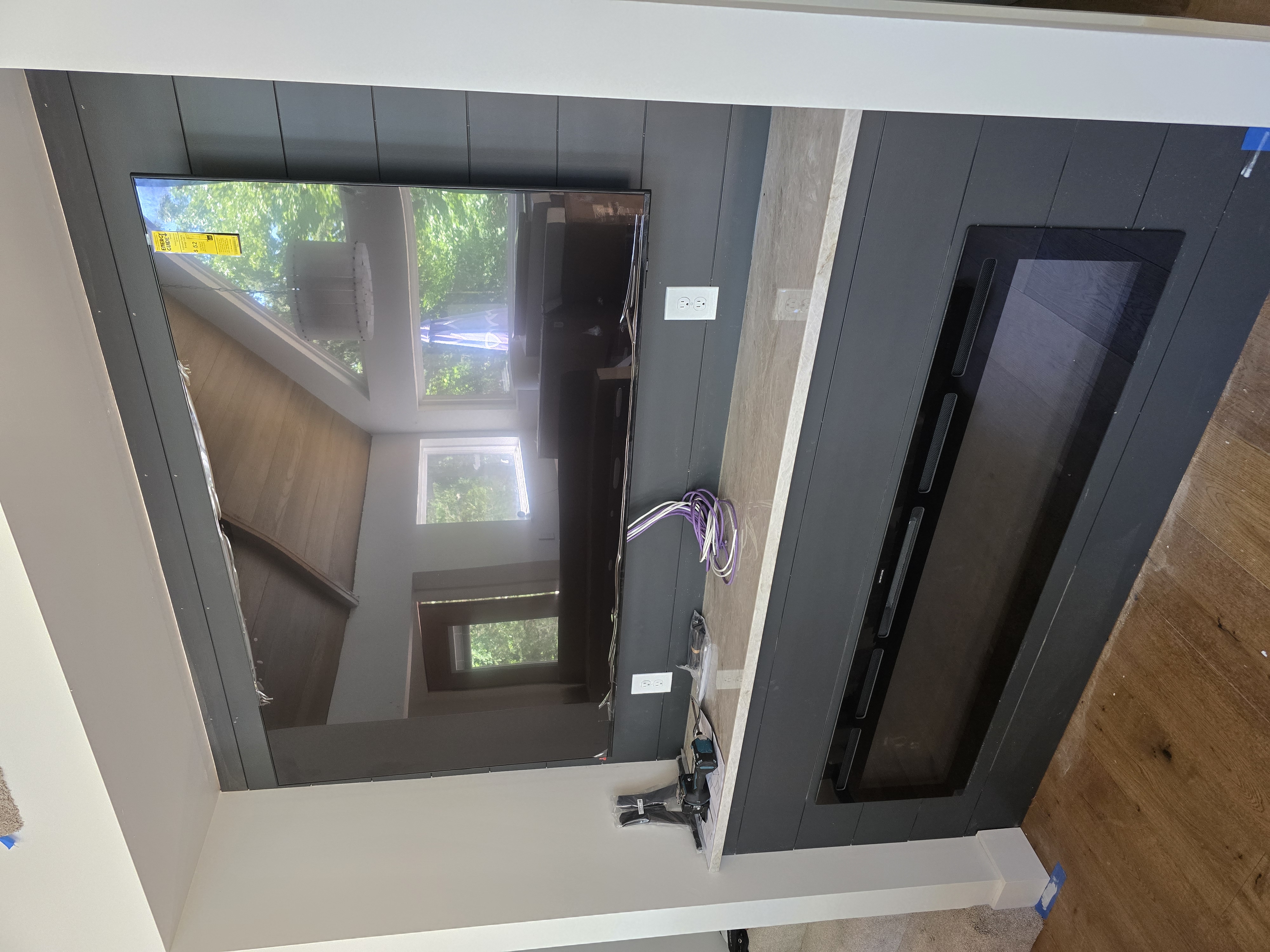 Dark shiplap accent wall with mounted display and in-wall speaker