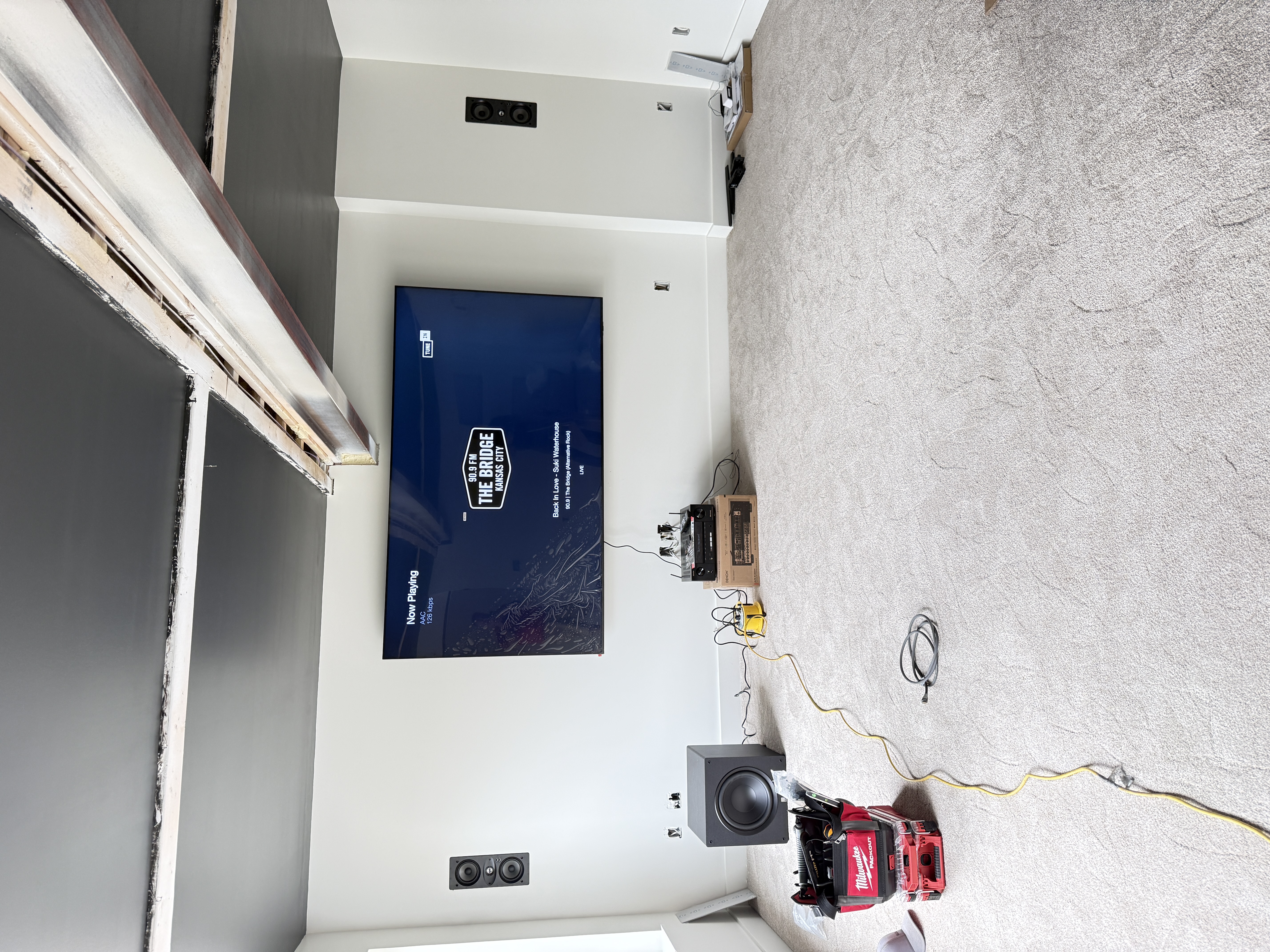 Display powered on with content playing — subwoofer placement during commissioning