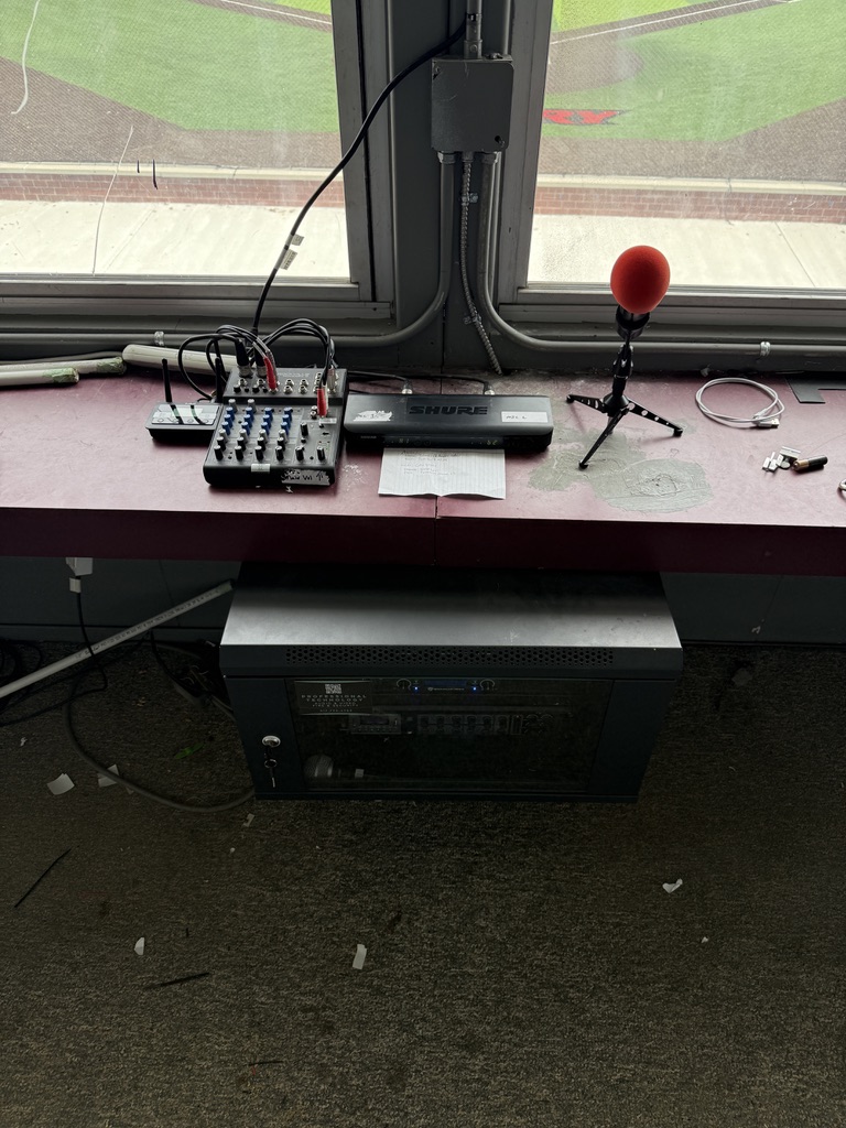 Commercial AV install at stadium press box with mixer and wireless mic